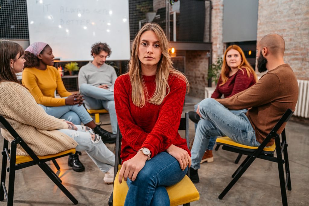 woman turning away from friends because she needs social anxiety treatment