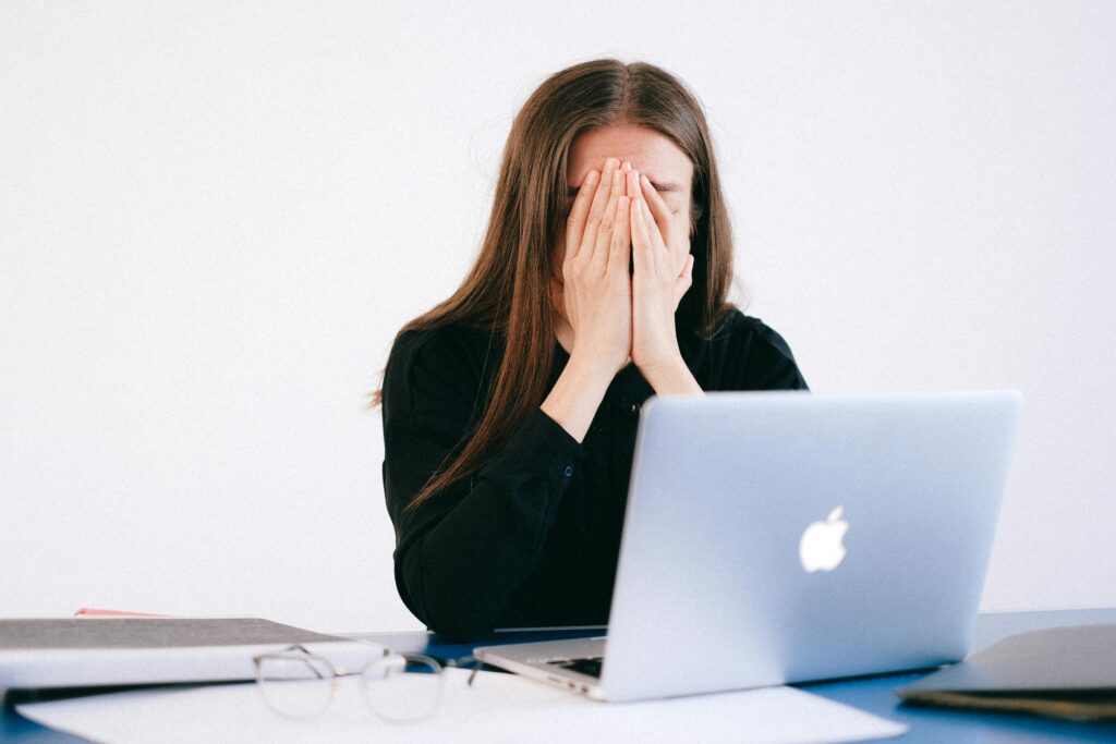 workplace anxiety - a woman covering her face with her hands